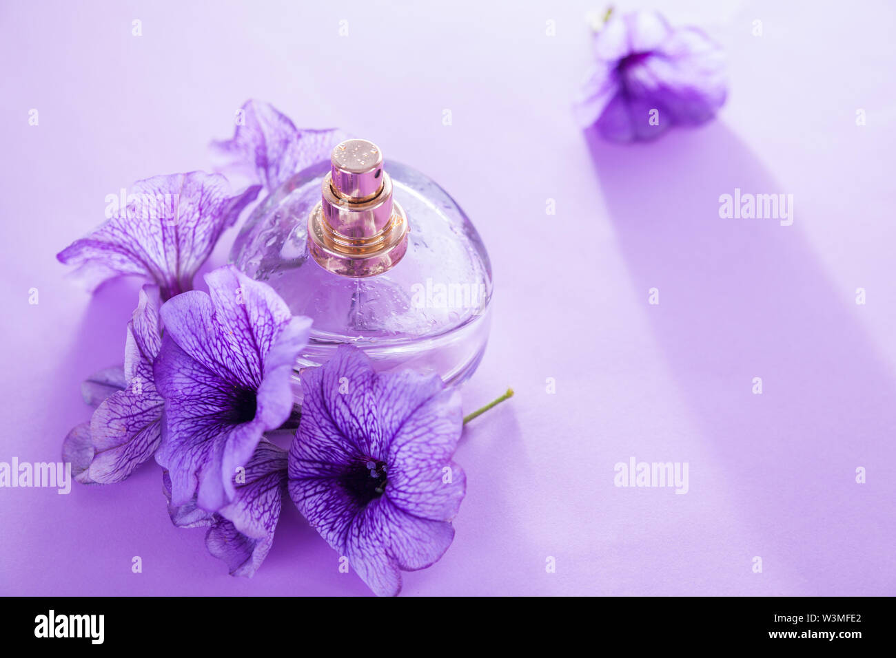 Bottle of perfume with flowers on 