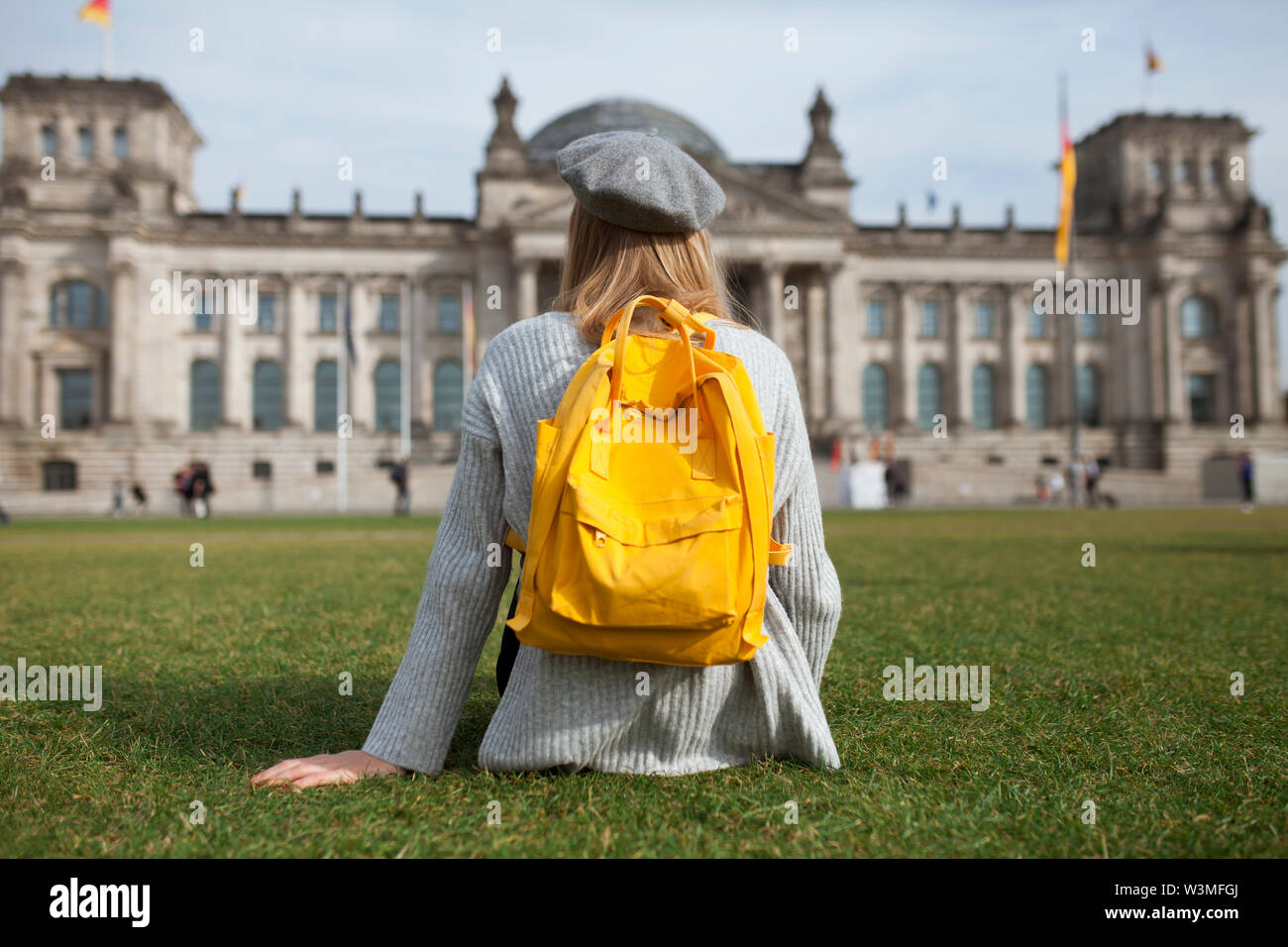 Young woman sitting in park by Reichstag in Berlin, Germany Stock Photo