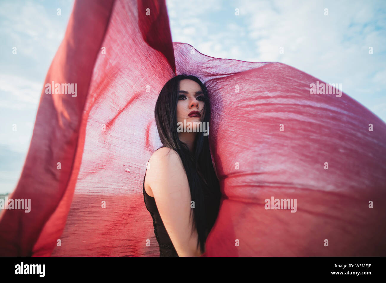 Young woman with windswept red scarf Stock Photo