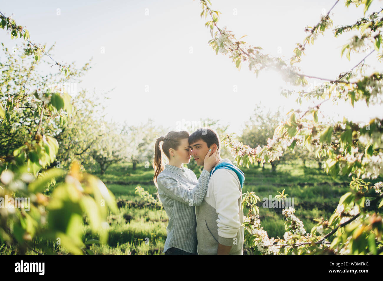 Young couple embracing by trees Stock Photo
