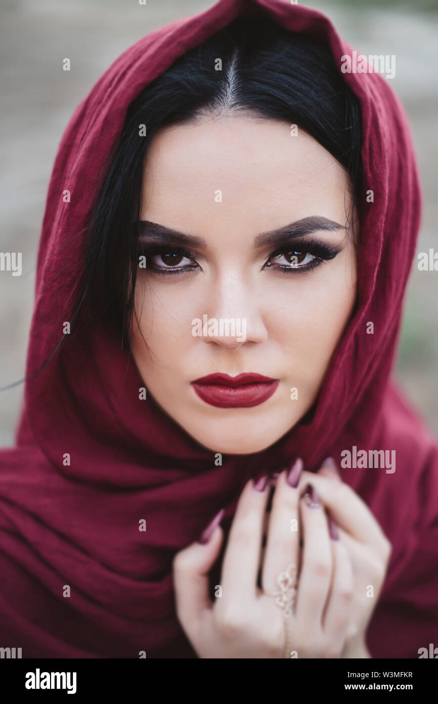 Portrait of young woman wearing red lipstick and headscarf Stock Photo