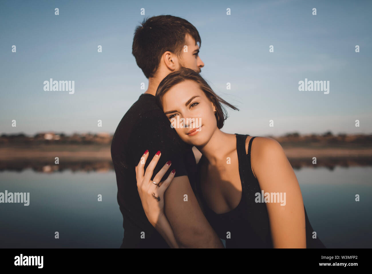 Young couple embracing by lake Stock Photo