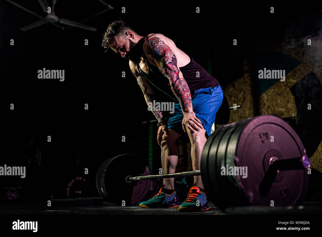 Man Snatche Exercise Muscular fitness man preparing to deadlift a barbell in modern fitness ...
