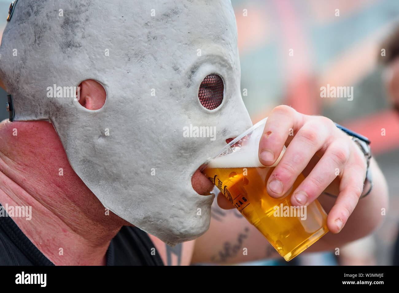 MADRID - JUN 30: A fan with the Slipknot mask drinks beer in a concert at Download (heavy metal music festival) on June 30, 2019 in Madrid, Spain. Stock Photo