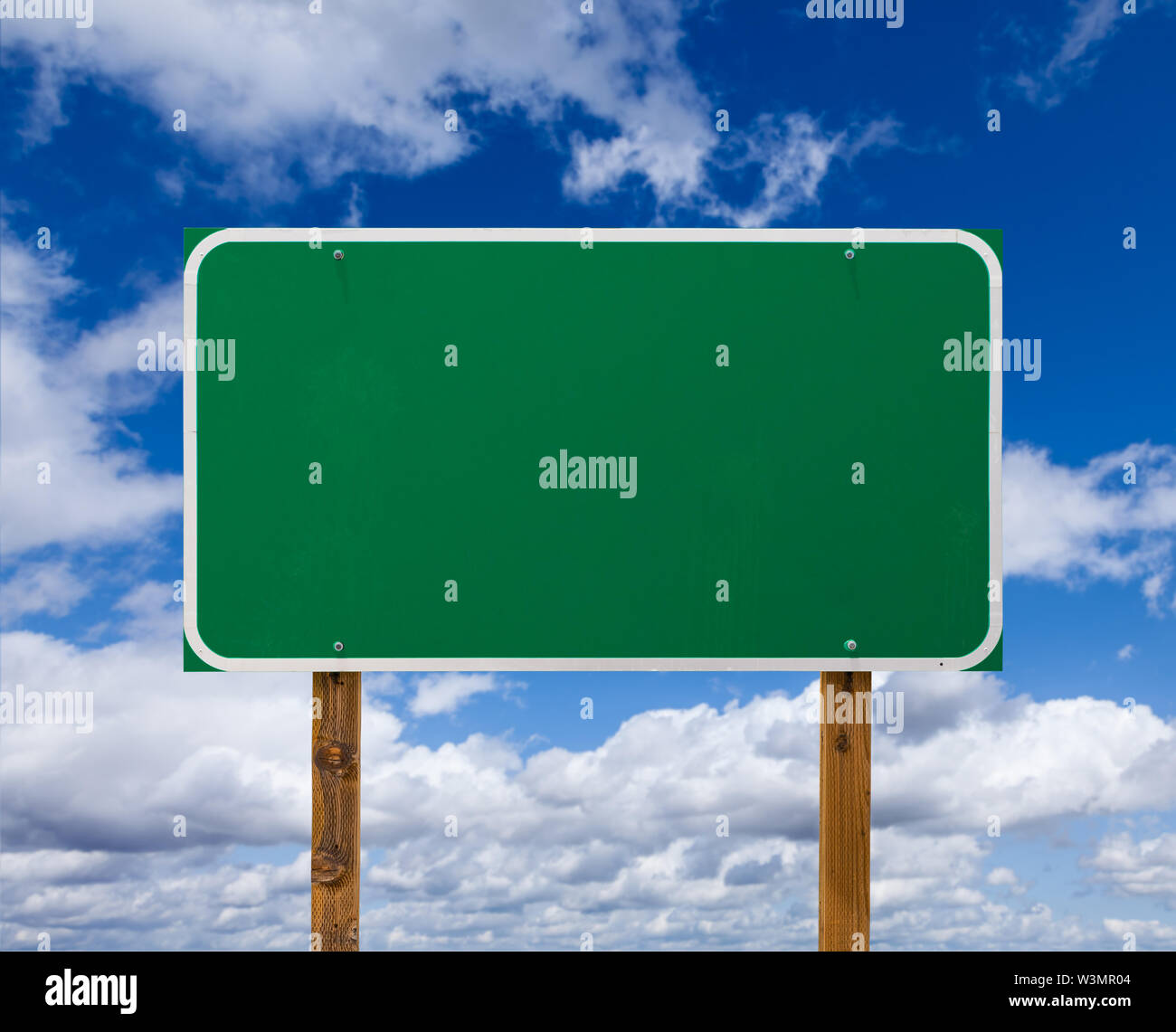 Blank Green Road Sign with Wooden Posts Over Blue Sky and Clouds Stock ...