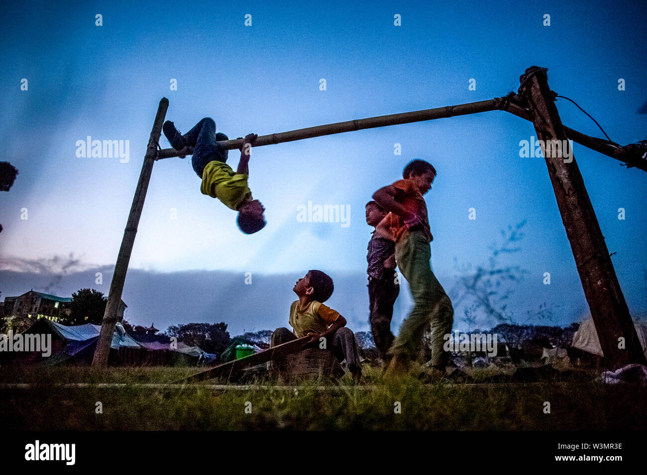 Children play on a bamboo pole at the temporary shelter center in Maidan, Kathmandu, after the 7.8 magnitude earthquake that struck Nepal at 11:56 am, on 25th April, 2015. Kathmandu, Nepal. May 1, 2015. Stock Photo