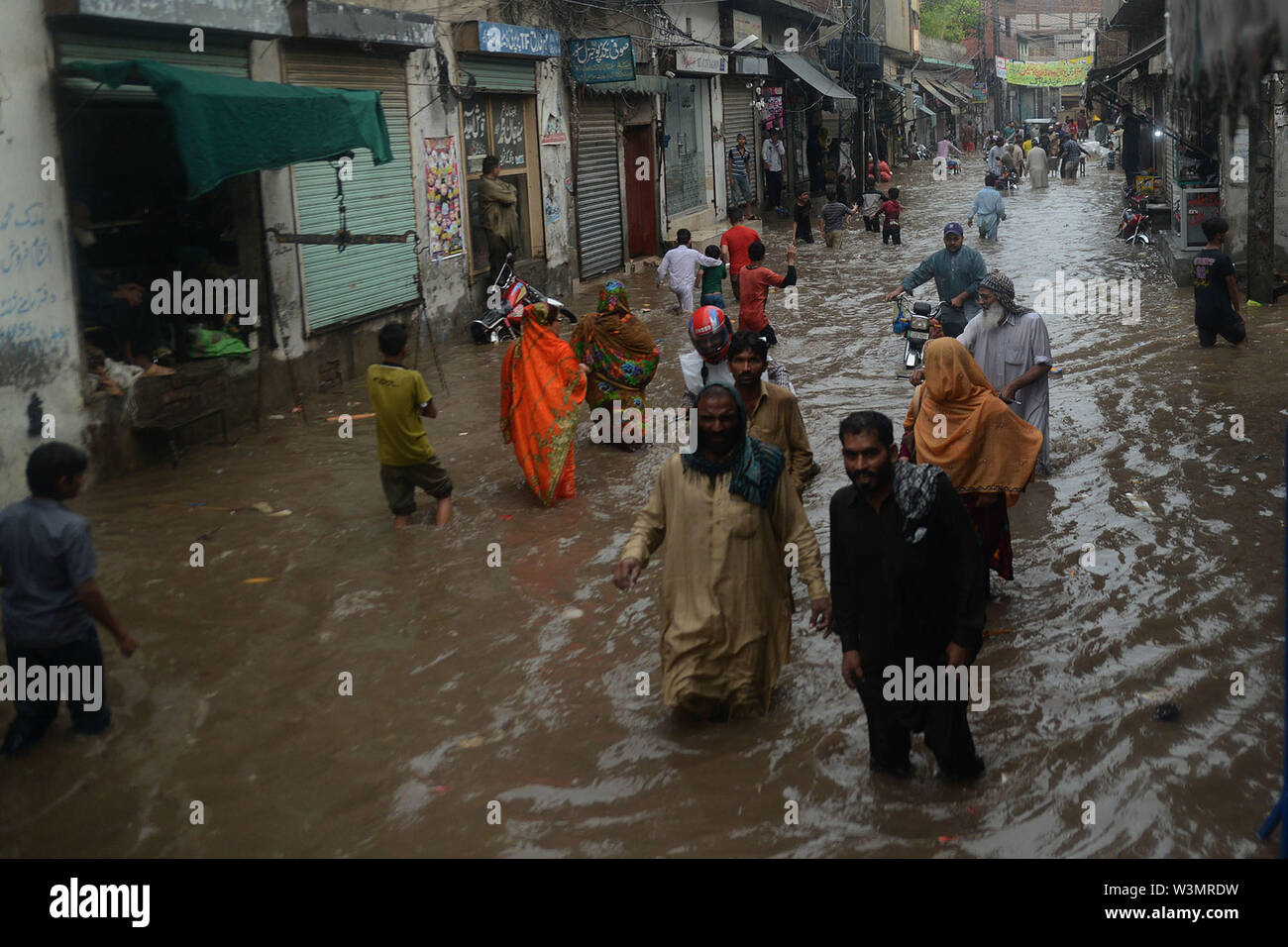 People facing troubles due to rainy water accumulated at China Scheme area as streets are presenting river view after the heavy monsoon rain in provincial. According to Met Department, heavy monsoon rain lashed Lahore and its adjoining areas in the wee hours of Tuesday. The incessant rain has flooded roads and streets in many parts of the city, rainwater entered houses in several low-lying areas of Lahore while parts of the city witnessed power outage as more that 150 Lesco feeders tripped soon after the rain started. Credit: PACIFIC PRESS/Alamy Live News Stock Photo