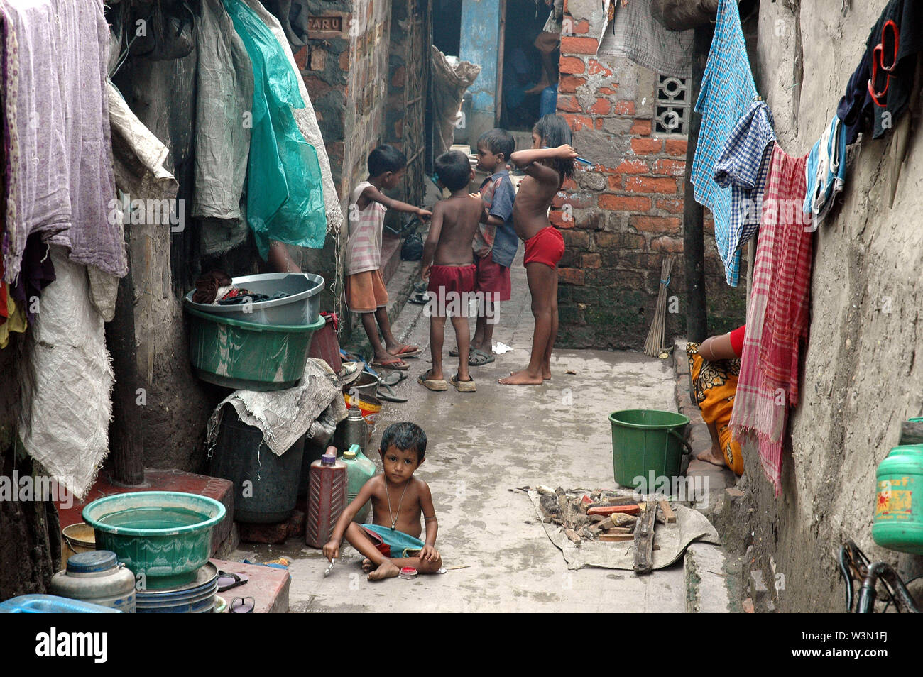 Children at a Road side slum of Kolkata city. Most of the transient roadside settlements and slums have been formed by refugees from East Pakistan. Infiltration in the city also takes place frequently from the villages of 24 Paraganas. The slum dwellers are mostly engaged as domestic servants, sweepers, daily laborers, small traders etc. India. July 17, 2005. Stock Photo