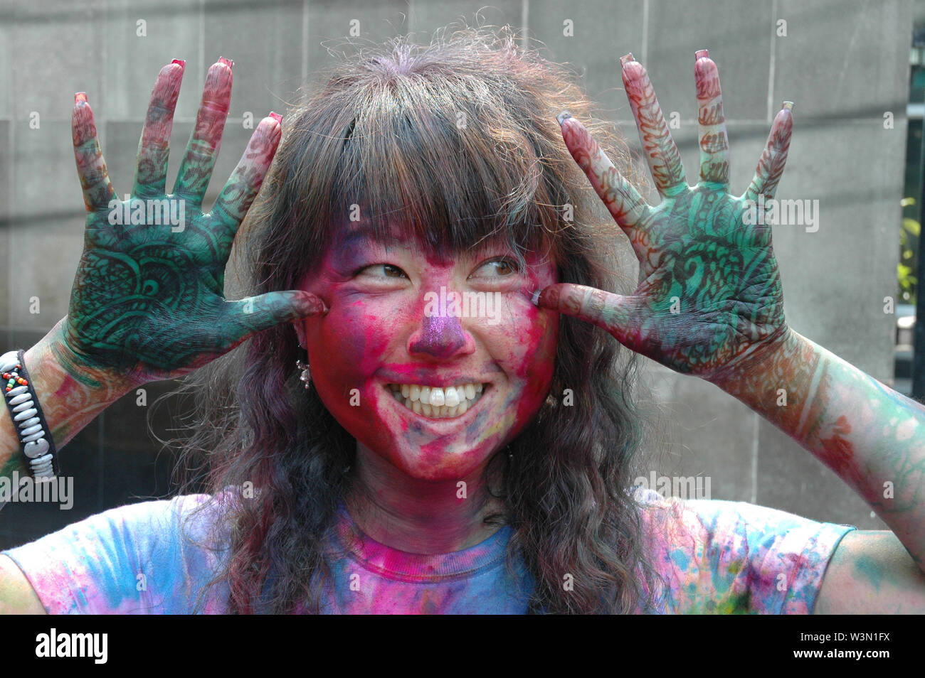 A color smeared foreign woman making funny faces during the holi festival  at Kolkata's Free School Street. Every year many foreigners come from all  over the world to participate in this colorful