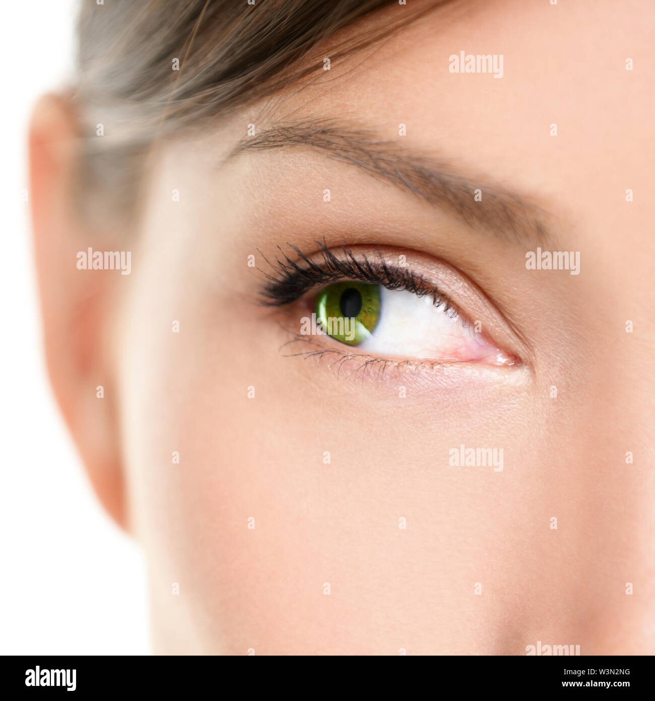 Eye Close-up looking to side. Closeup portrait of female eyee with beautiful green color looking sideways at empty white copy space. Mixed race Asian Caucasian women model. Stock Photo