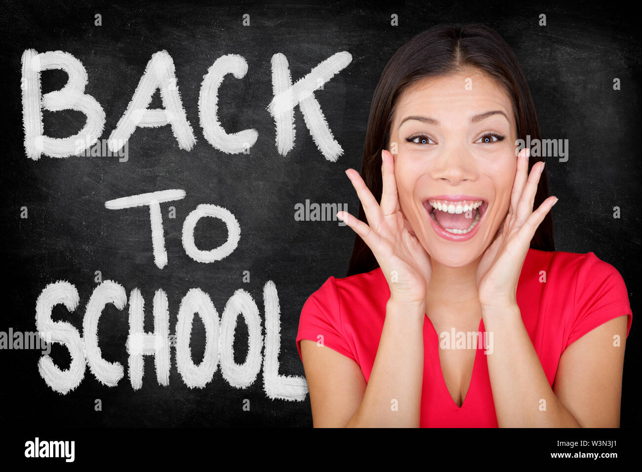 Back to School. Student screaming yelling BACK TO SCHOOL with text on blackboard. Female university college student standing in front of chalkboard. Ethnic Asian Caucasian woman student. Stock Photo