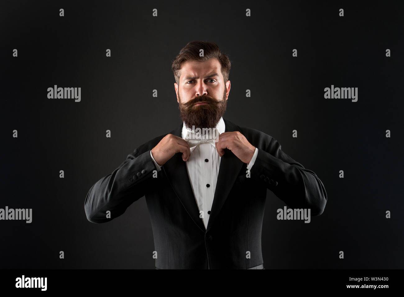 Bearded man with bow tie. Well dressed and scrupulously neat. Hipster formal suit tuxedo. Difference between vintage and classic. Official event dress code. Classic style. Menswear classic outfit. Stock Photo