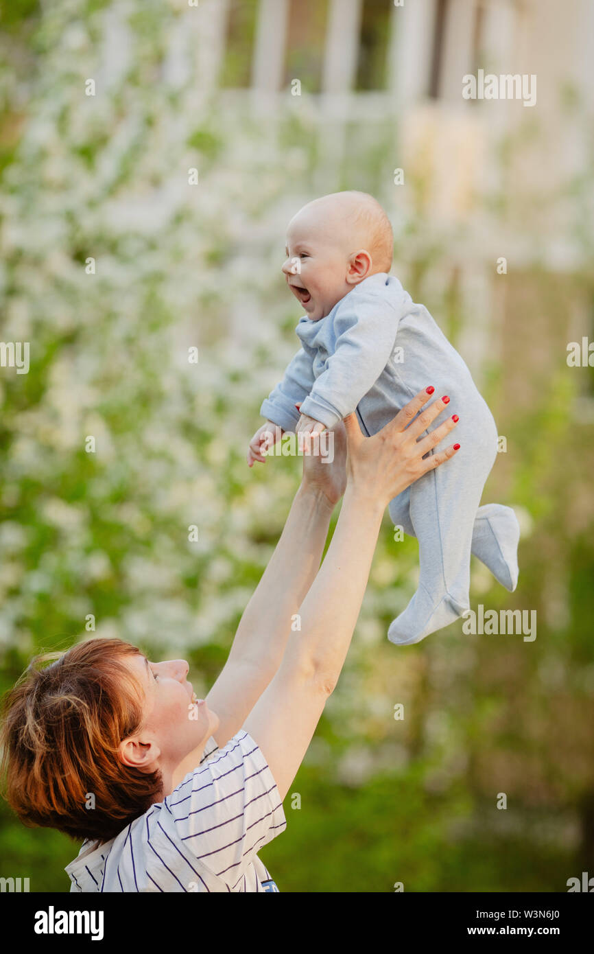Young mother tossing baby in air Stock Photo Alamy