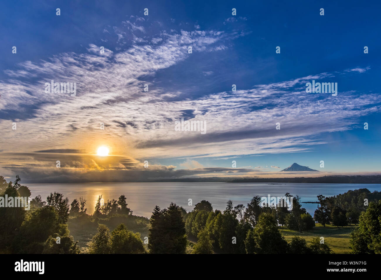 A dramatical sky view in between the clouds over Rupanco Lake, one of the Great lakes in Southern Chile during sunrise an amazing volcanic landscape Stock Photo