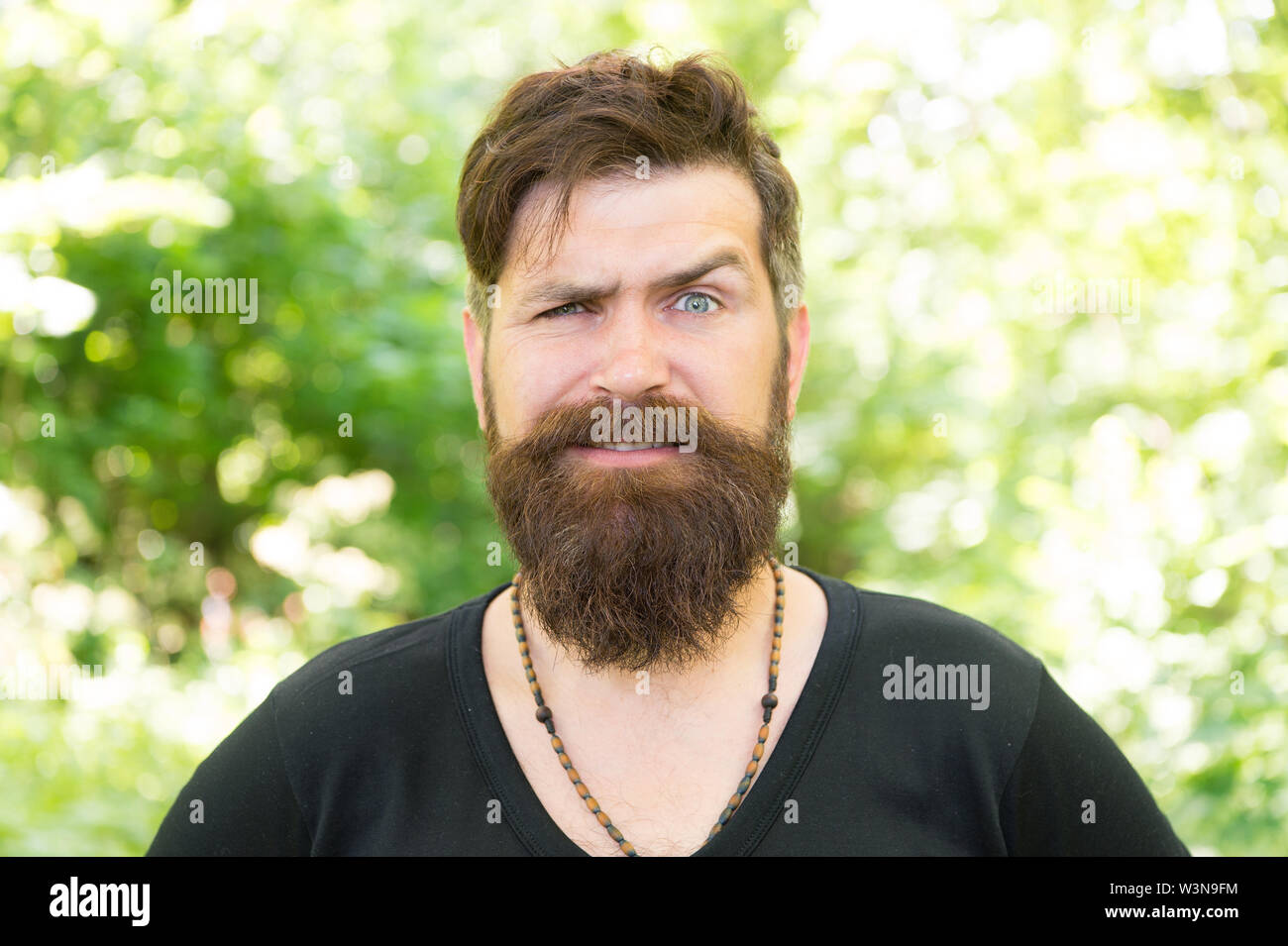 Wild nature. Man bearded hipster bright foliage background. Guy relax in summer forest. Handsome man with beard and mustache summer vacation. Brutality of jungles concept. Summer heat season concept. Stock Photo