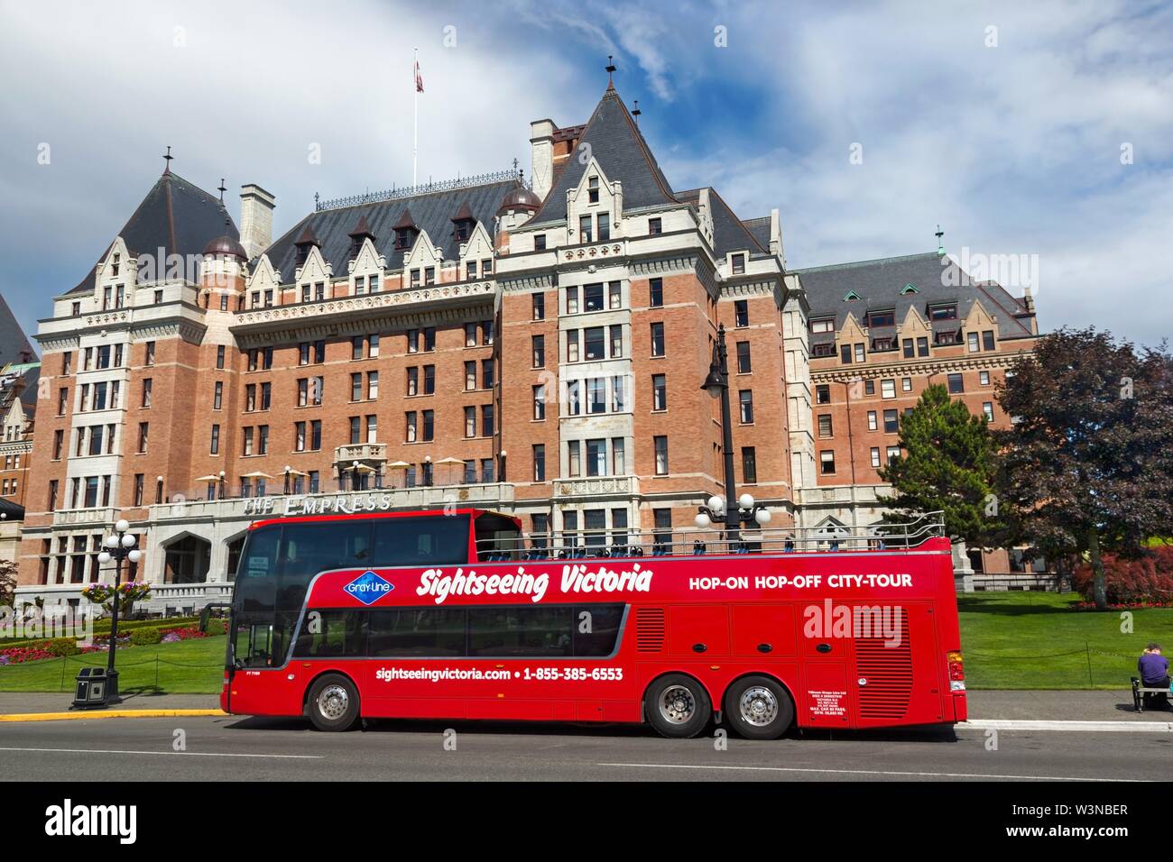 Sightseeing Victoria Red Tourist Double Decker Bus in front of Historic Fairmont Empress Hotel on Government Street in City Center Inner Harbour Stock Photo