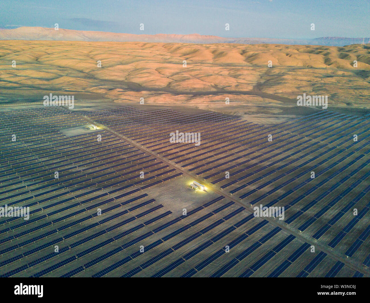 Aerial view of hundreds solar energy modules or panels rows along the dry lands at Atacama Desert, Chile. Huge Photovoltaic PV Plant in an arid scene Stock Photo