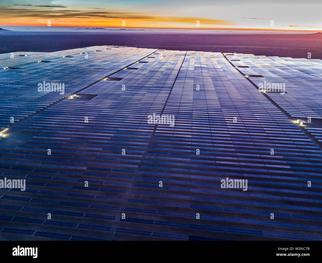 Aerial view of hundreds solar energy modules or panels rows along the dry lands at Atacama Desert, Chile. Huge Photovoltaic PV Plant in an arid scene Stock Photo