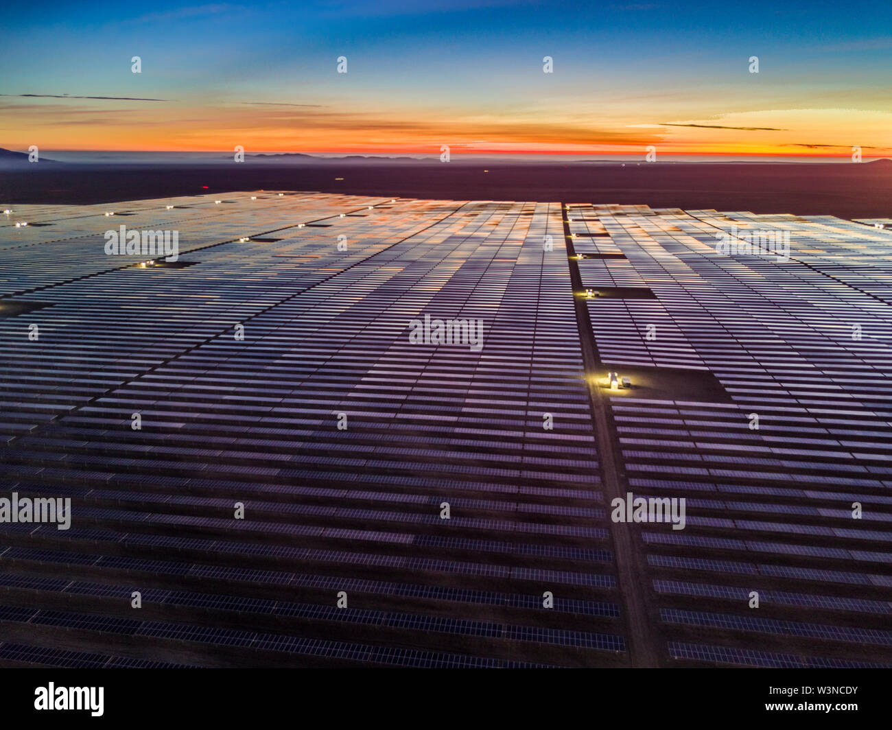 Aerial view of hundreds solar energy modules or panels rows along the dry lands at Atacama Desert, Chile. Huge Photovoltaic PV Plant in an arid scene Stock Photo