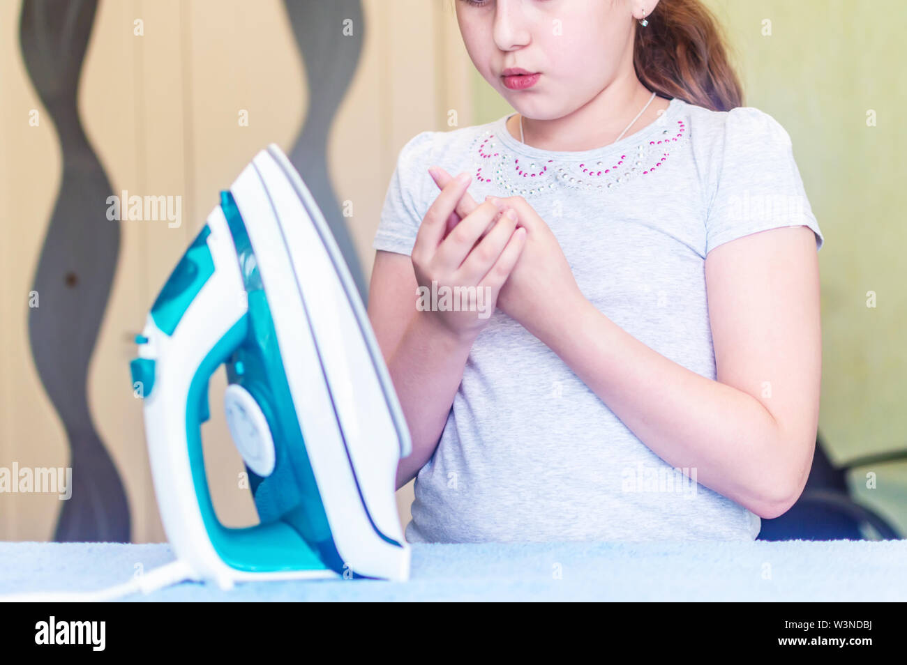 the girl received a burn when Ironing clothes on the Ironing Board with