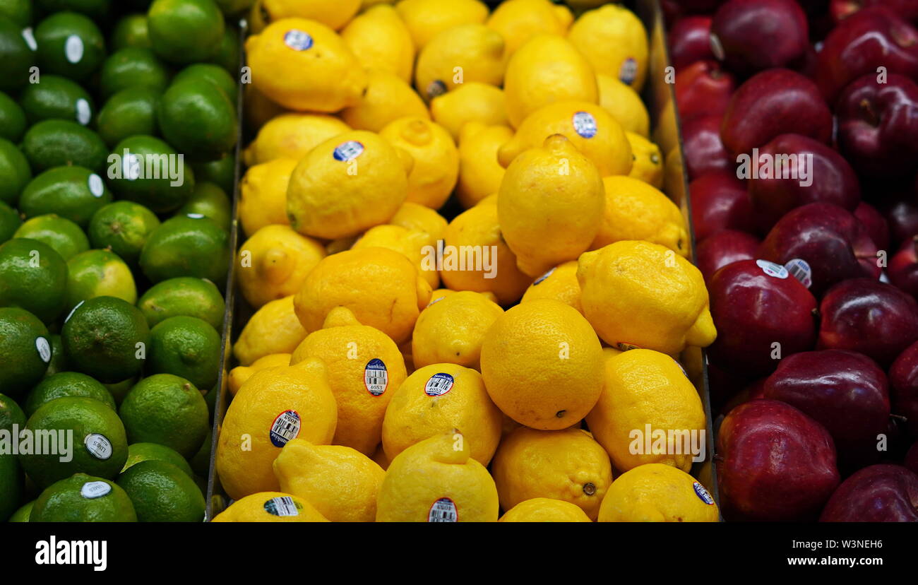 New London, CT / USA - June 2, 2019: Limes, lemons, and apples, lined up in the produce aisle Stock Photo
