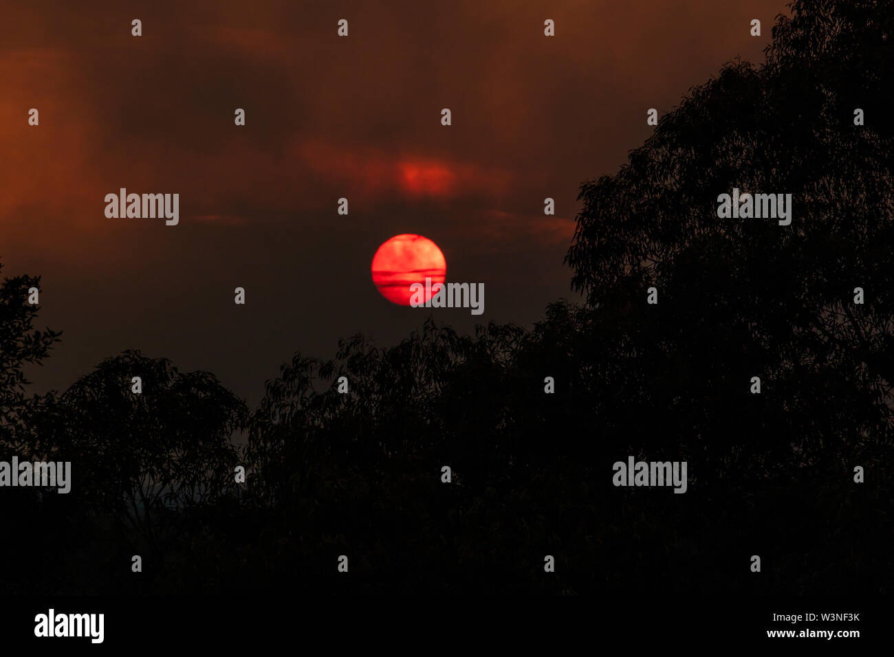 The sun shrouded in the smoke of a large bush fire in The Blue ...
