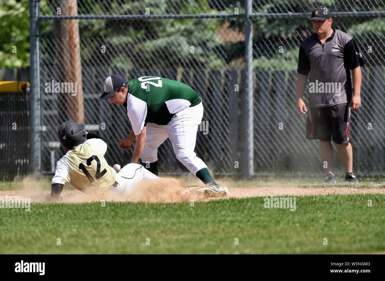 Runner sliding safely back into first base to avoid a double play. USA
