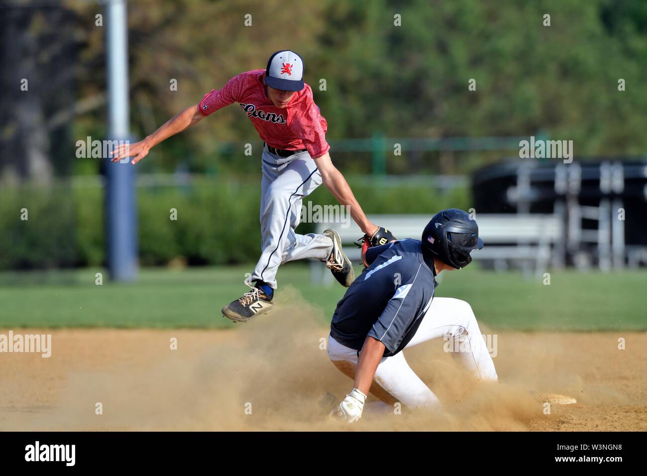 Runner sliding safely into second base as the second baseman made a leaping tag on a pick-off play. USA. Stock Photo