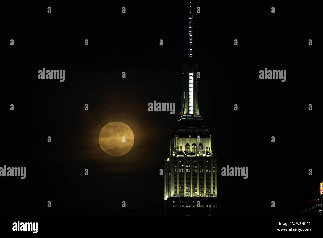 Hoboken, United States. 16th July, 2019. Full moon is seen near Empire State Building in New York, from the city of Hoboken in New Jersey at night time Tuesday, 16. Today celebrates 50 years that Neil Amstrong, the first man who stepped on the moon. Credit: Brazil Photo Press/Alamy Live News Stock Photo