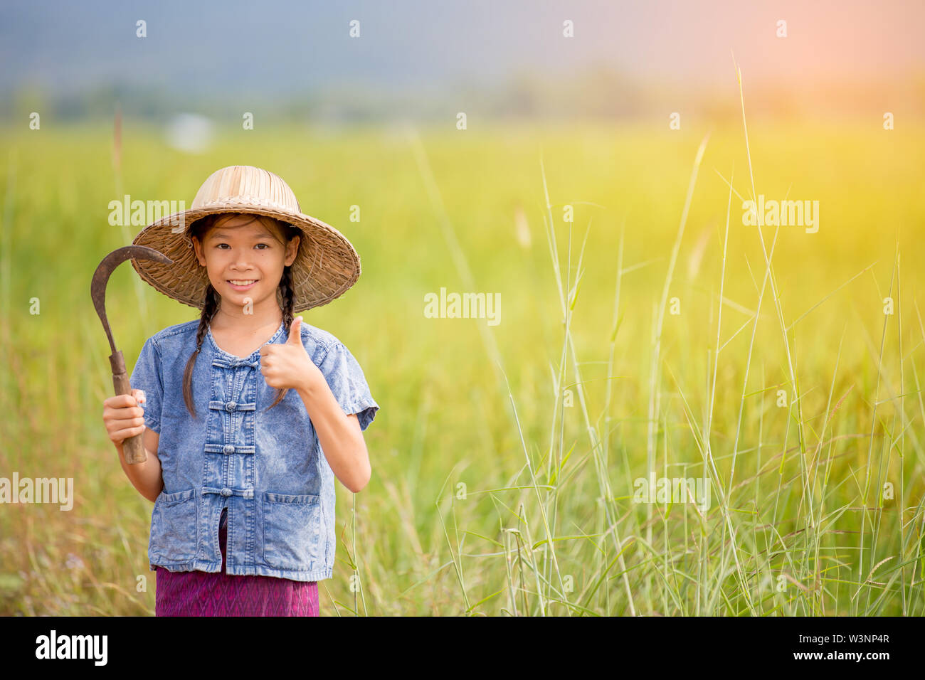 portrait of little smiling girl farmer on green field Stock Photo