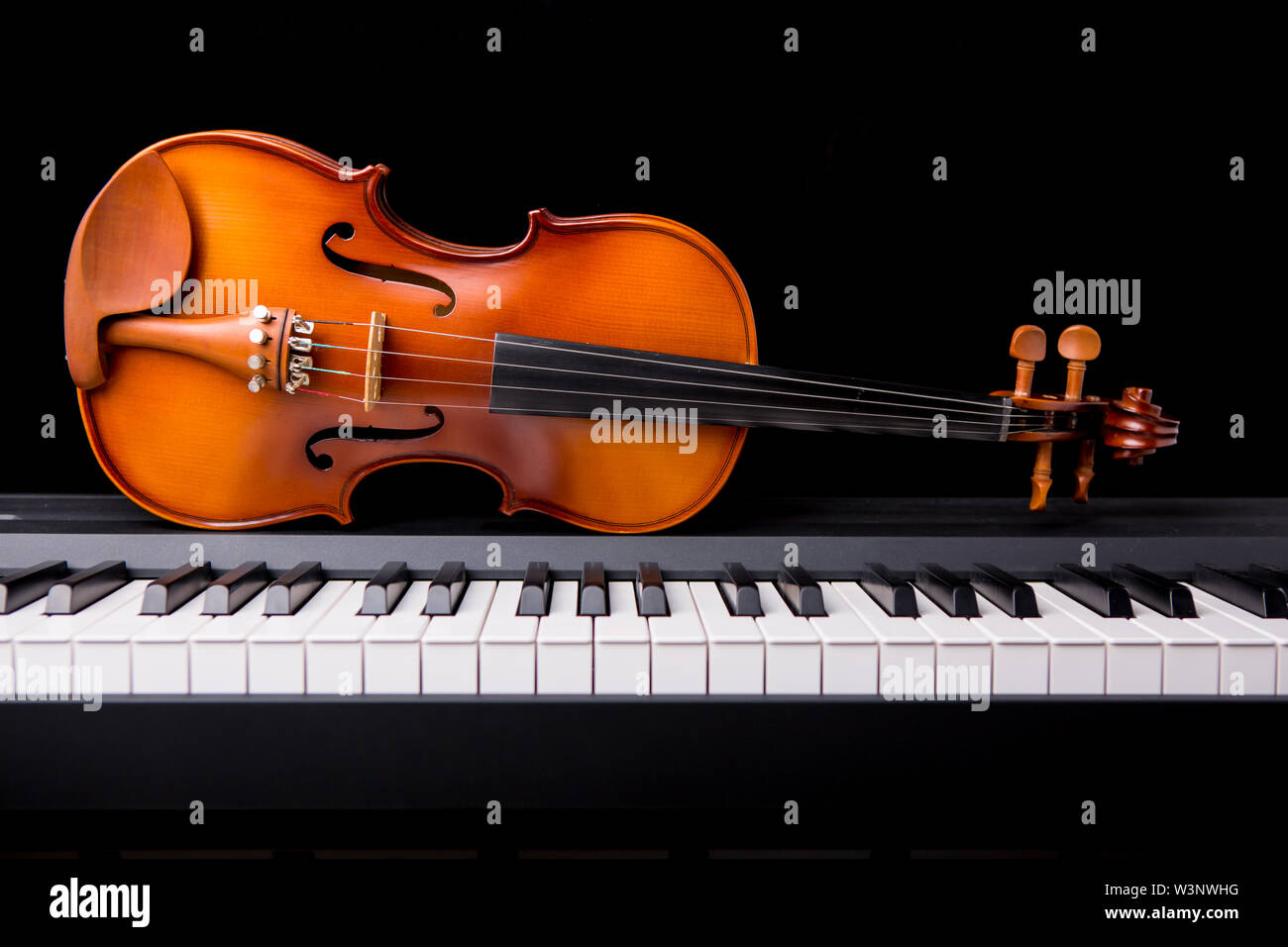 Violin on the piano on a black background Stock Photo - Alamy