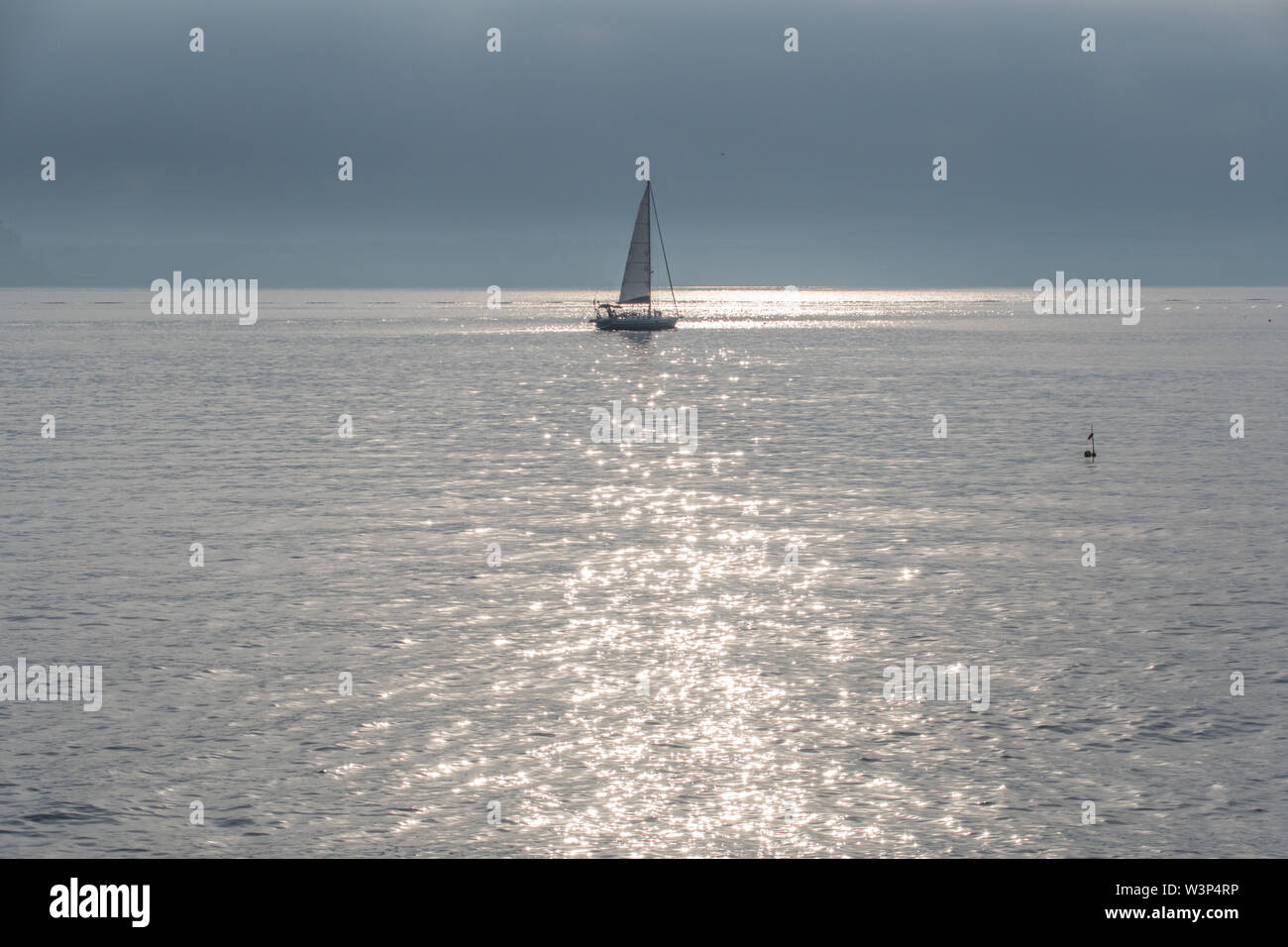 Newlyn, Cornwall, UK. 17th July 2019. UK Weather.  Warm and sunny but not much wind for this sailing boat leaving it's overnight mooring at Newlyn.  Credit Simon Maycock / Alamy Live News. Stock Photo