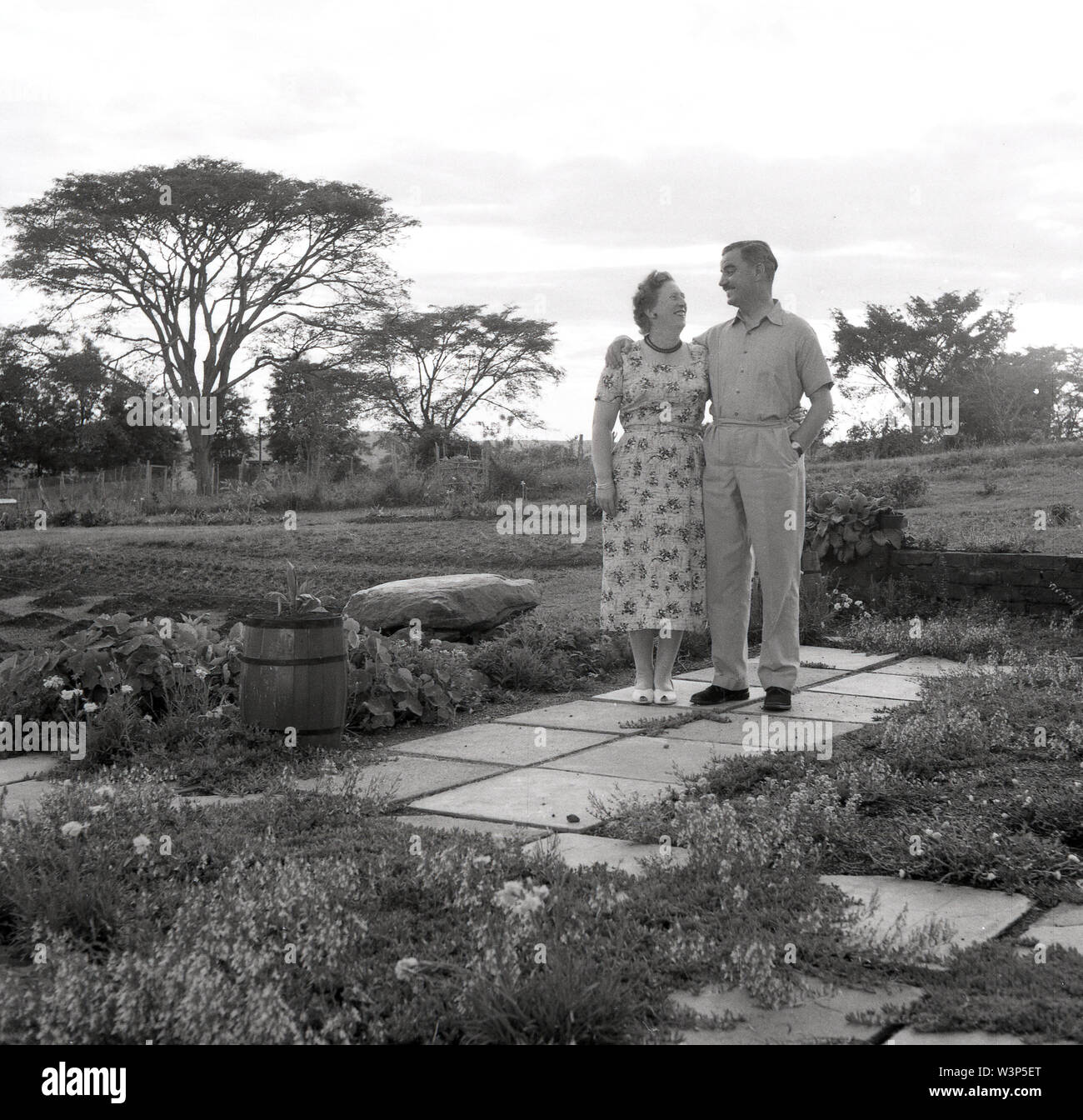 1950s, historical, Elderly British couple standing together outside their property, Uganda. The African country was a British protectorate from 1894 to 1962 and after WW11 many ex-army officers stayed on to start a new life there particuarly in farming the land. Stock Photo