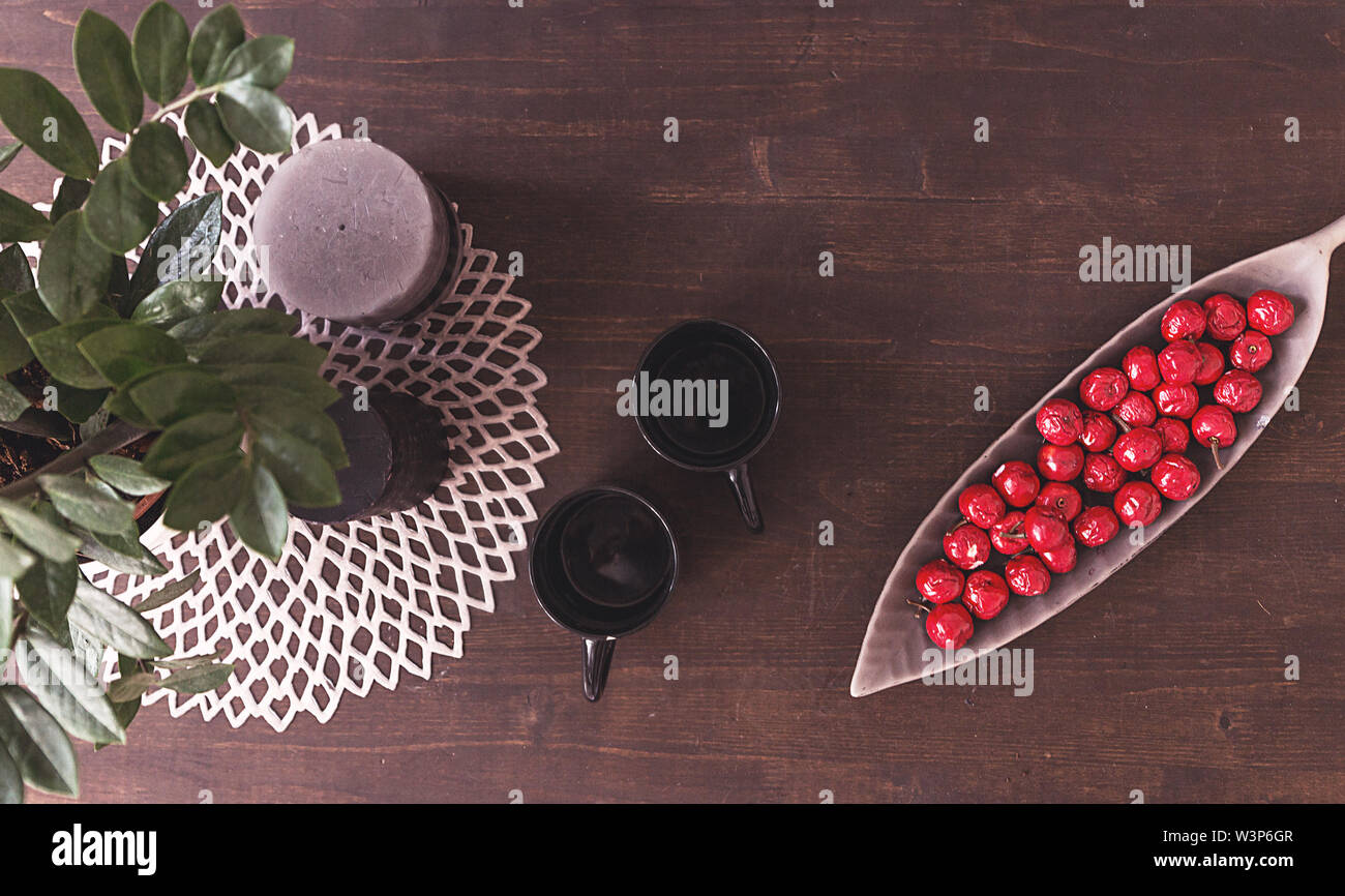 Table with two empty cups and artificial berries in a plate Stock Photo