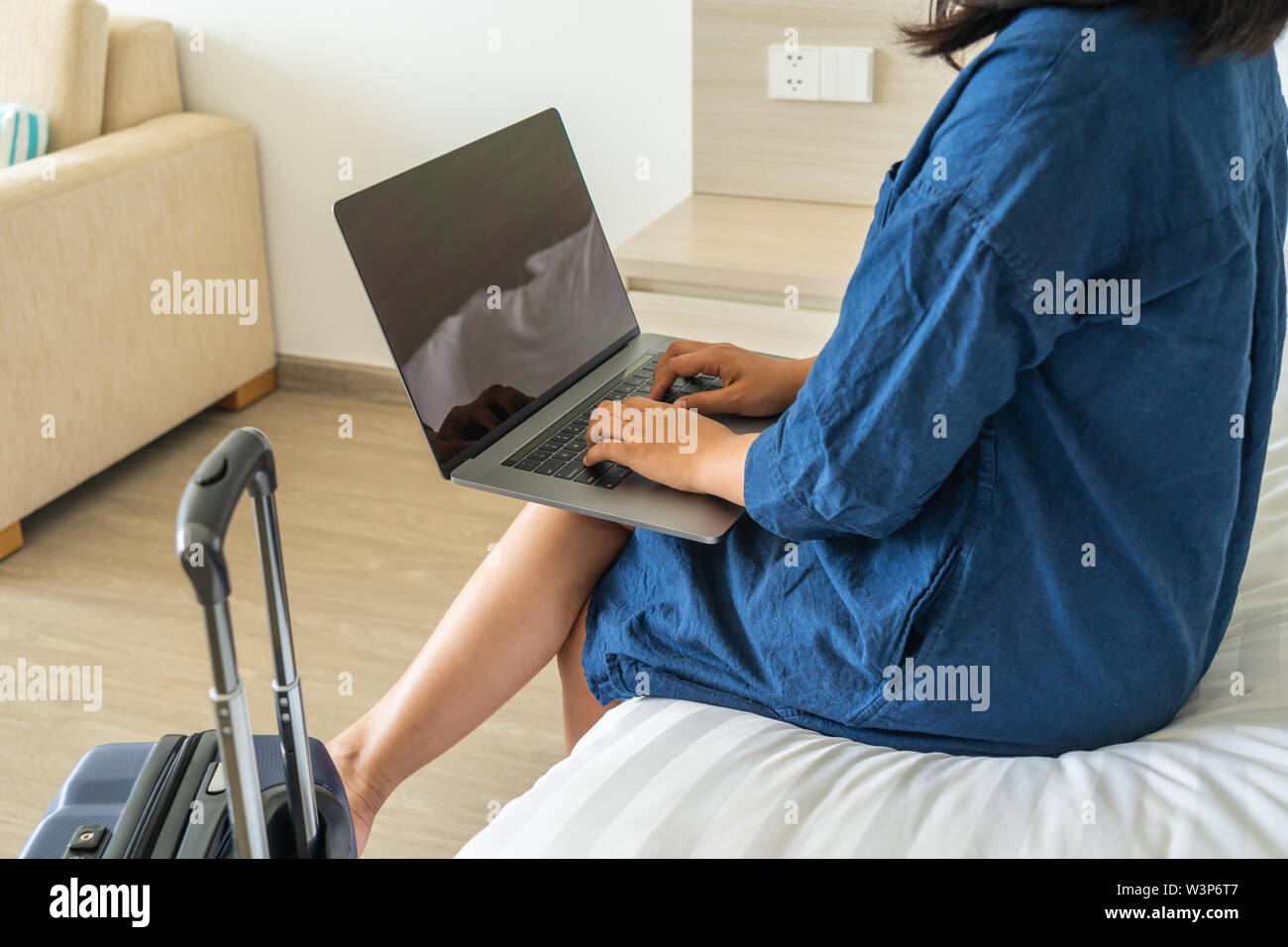 Woman using laptop put on thigh while sitting on bed Stock Photo Alamy