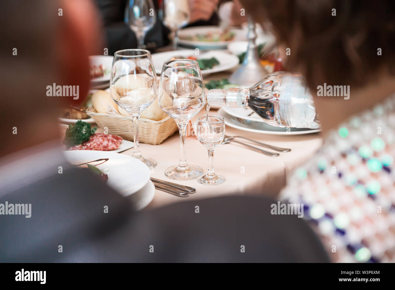 the waiter pours vodka from a bottle Stock Photo