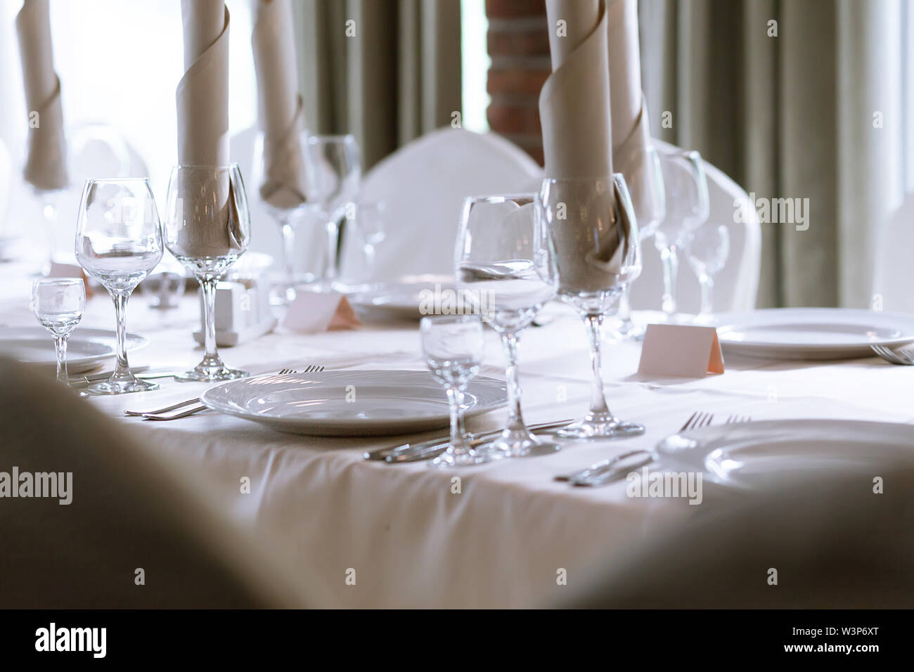 Elegant table setting in the restaurant. Several types of glass, plates