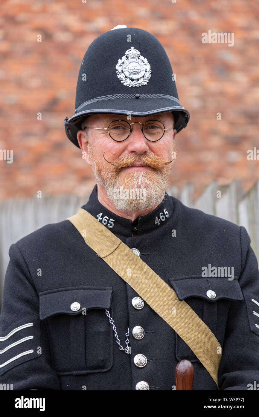 Man dressed as an old fashioned policeman wearing a helmet with impressive moustache, UK Stock Photo