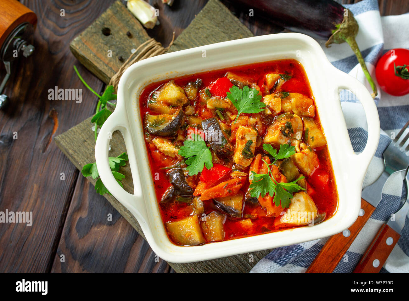 Thanksgiving day food concept. Homemade stewed turkey with vegetables on dark rustic background. Free space for your text. Stock Photo