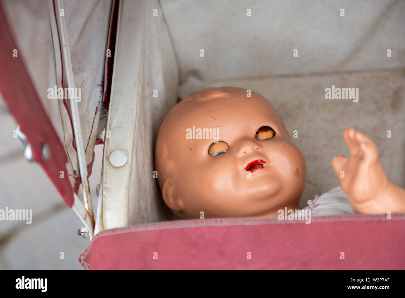 Old fashioned traditional baby doll in a pram Stock Photo