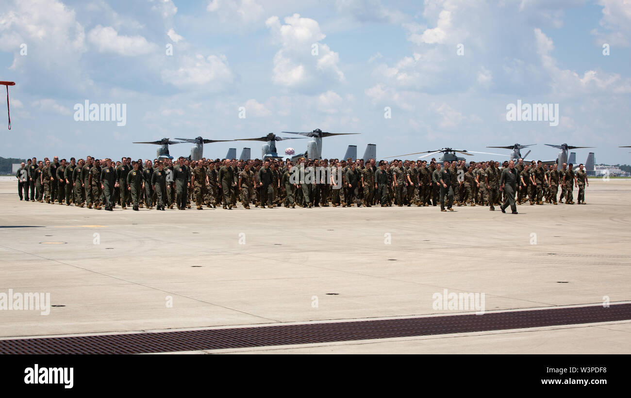 U.S. Marines and Sailors assigned to Marine Medium Tiltrotor Squadron (VMM) 264 walk in formation during a homecoming reception at Marine Corps Air Station New River, North Carolina, July 14, 2019. The Marines and Sailors returned from a deployment with the 22nd Marine Expeditionary Unit. (U.S. Marine Corps photo by Cpl. Cody Rowe) Stock Photo