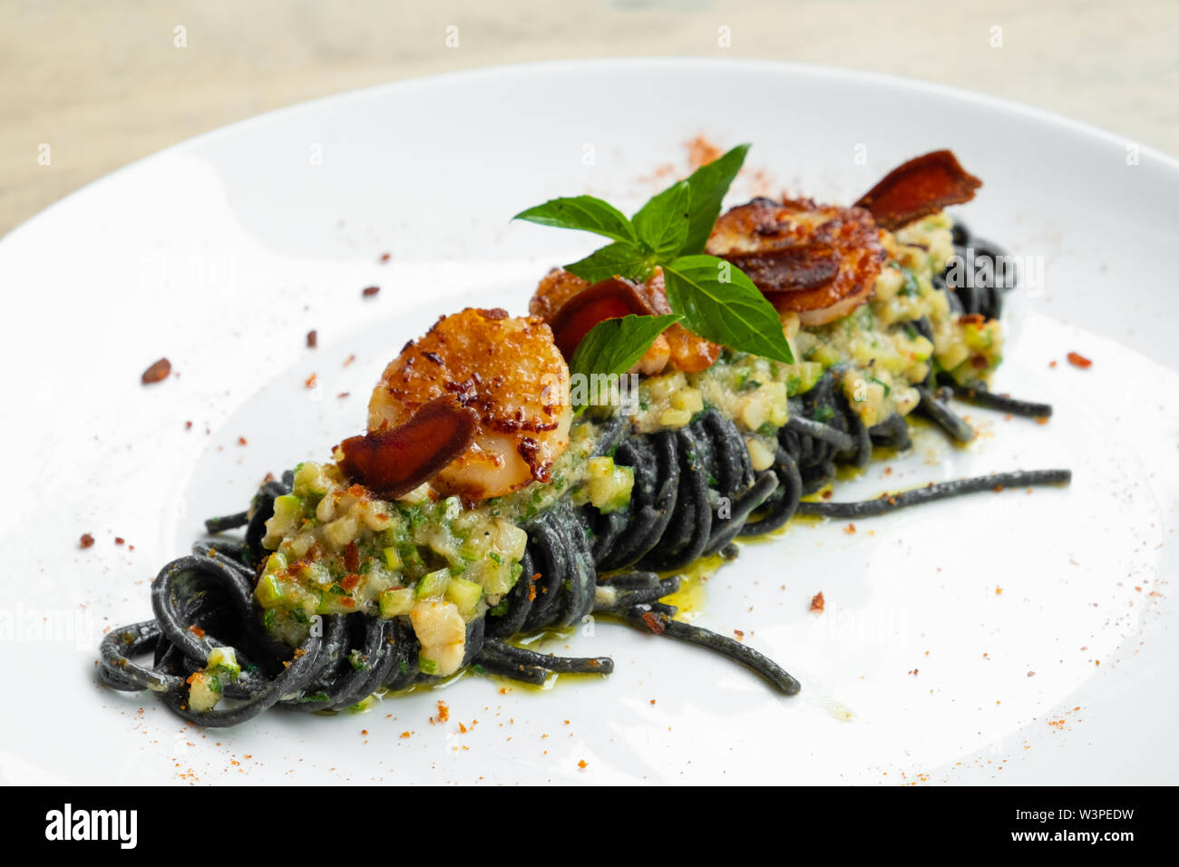 close up of tagliolini squid black ink pasta scallop seafood sauce