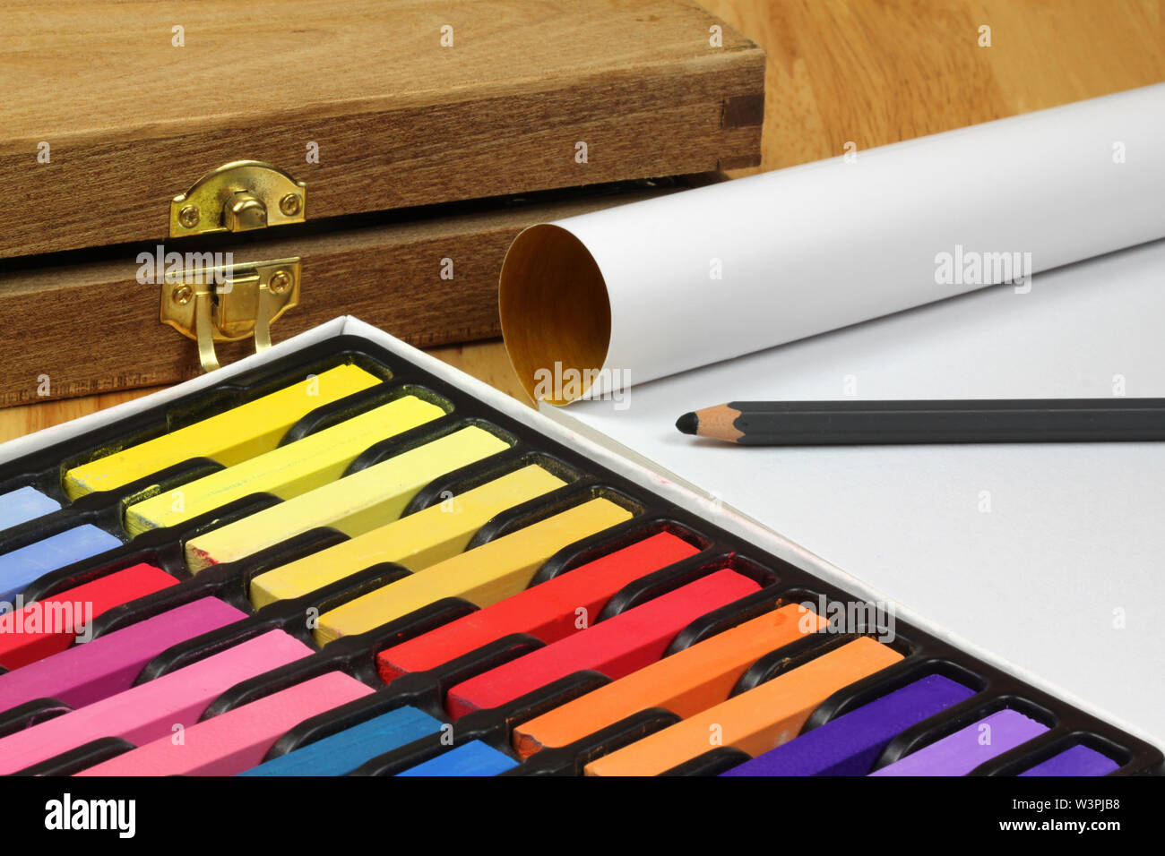 Multicolored artist's chalk pastels, cartridge paper and wooden box