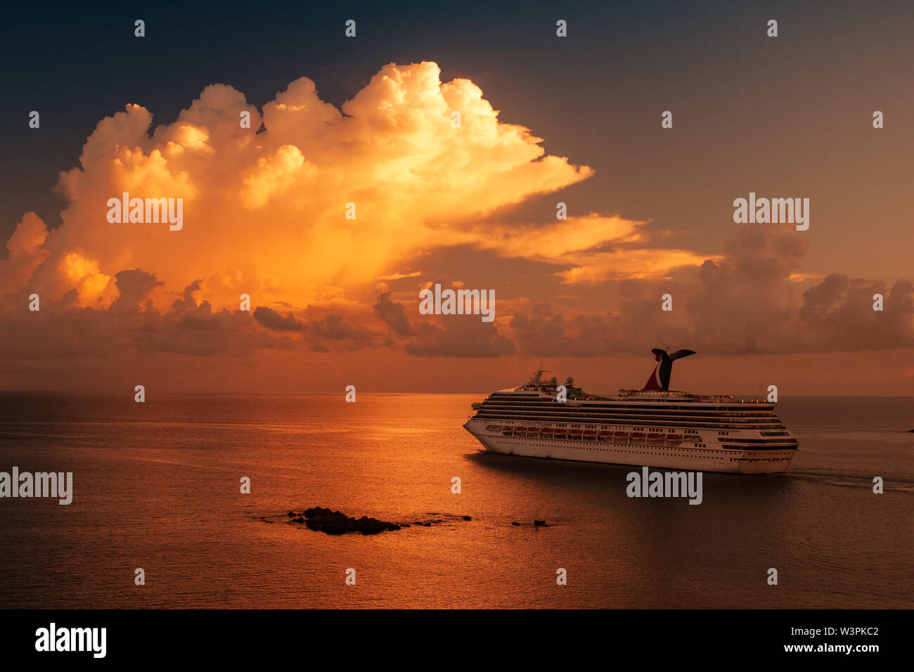 Saint Thomas / Virgin Islands / USA - September 5.2007: View on the massive white cruise ship sailing in the sunset with white clouds. Stock Photo