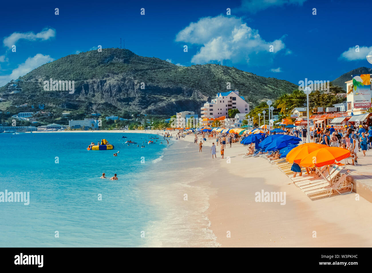 Sint Maarten / Caribbean / Netherlands - January 23.2008: Summer view on the sandy beach with people resting and swimming in the turquoise color sea. Stock Photo
