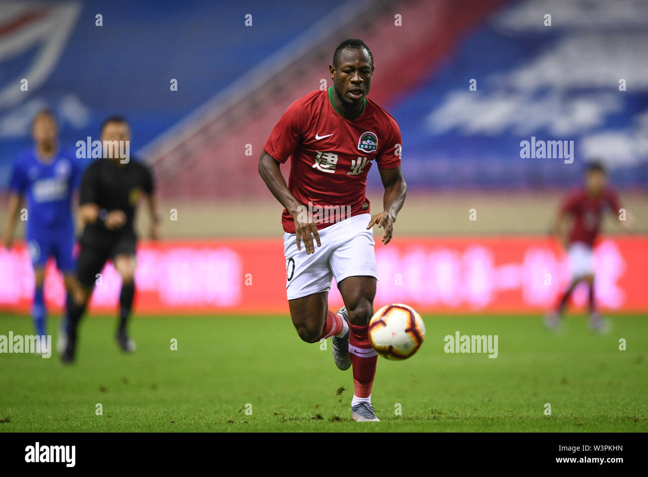 Cameroonian football player Christian Bassogog of Henan Jianye F.C. keeps the ball during the 18th round of Chinese Football Association Super League (CSL) against Shanghai Greenland Shenhua in Shanghai, China, 16 July 2019. Stock Photo