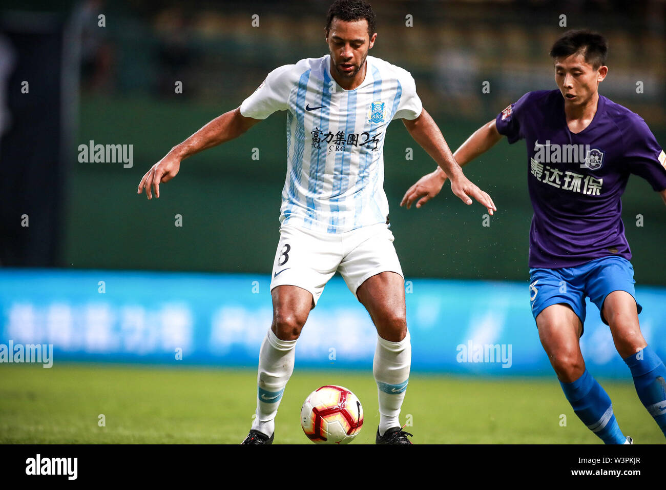 Belgian football player Mousa Dembele of Guangzhou R&F F.C., the one  wearing No.8 shirt, keeps the ball during the 18th round of Chinese  Football Association Super League (CSL) against Tianjin TEDA in