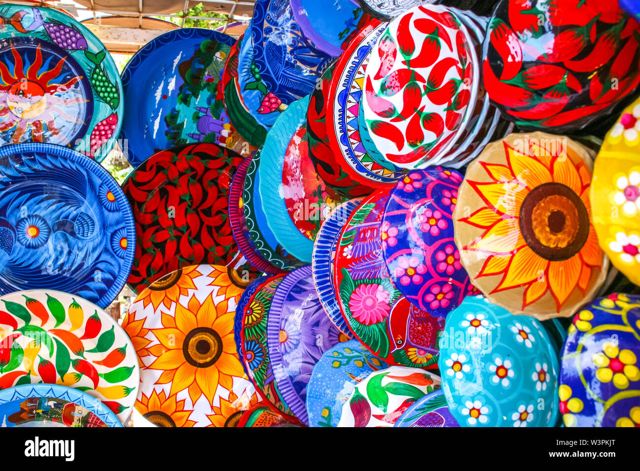 Colorful handmade decorative mexican plates with many patterns on the display on the local market in Puerto Vallarta Stock Photo