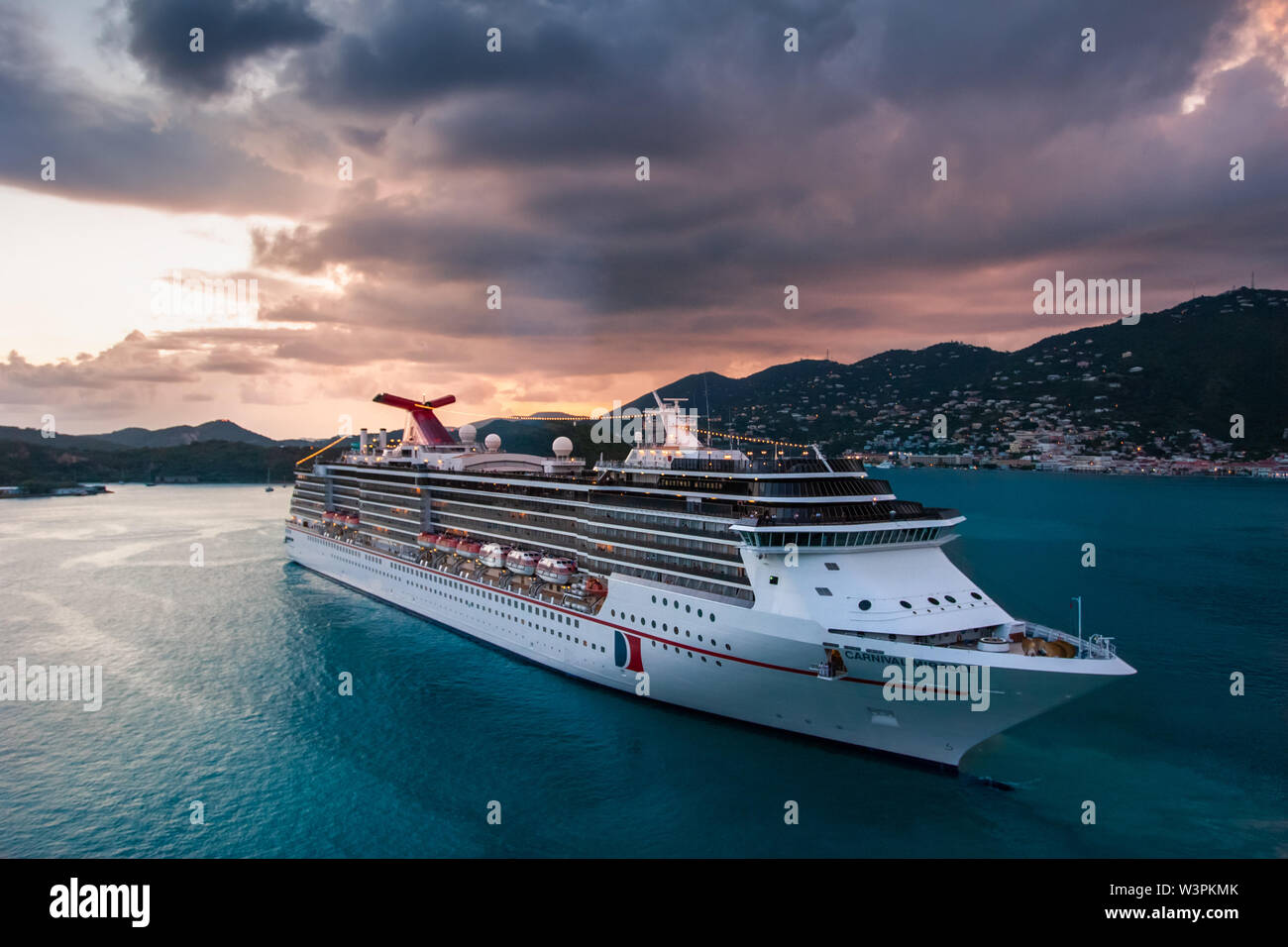 Saint Thomas / Virgin Islands / USA - September 5.2007: View on the massive white cruise ship sailing in the sunset with stormy, dramatic clouds. Stock Photo