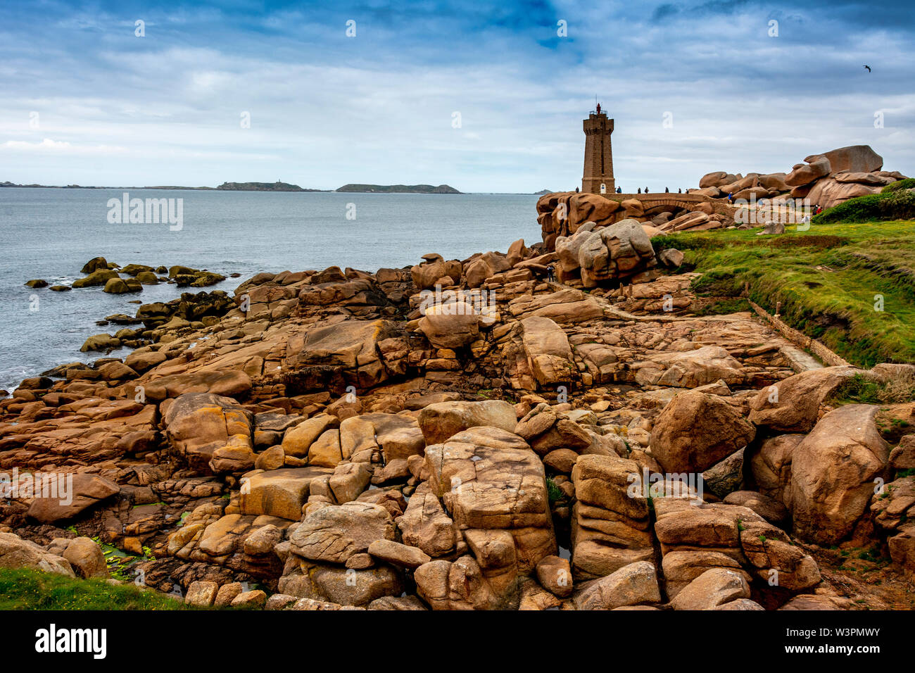 Ploumanach Mean Ruz lighthouse red sunset in pink granite coast, Perros Guirec, Cotes d'Armor, France Stock Photo